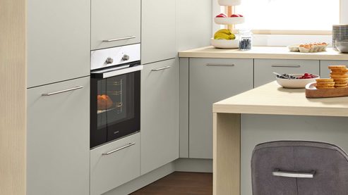 Einbauküche Interliving aus Holz in Hellgrau Interliving Küche Serie 3111 mit Constructa-Einbaugeräten Platingrau & Sandesche - dreizeilig