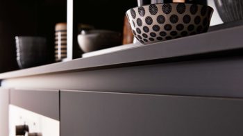 Einbauküche Interliving aus Holz in Schwarz Interliving Küche Serie 3035 mit AEG Einbaugeräten Schwarz & Quarzgrau – zweizeilig