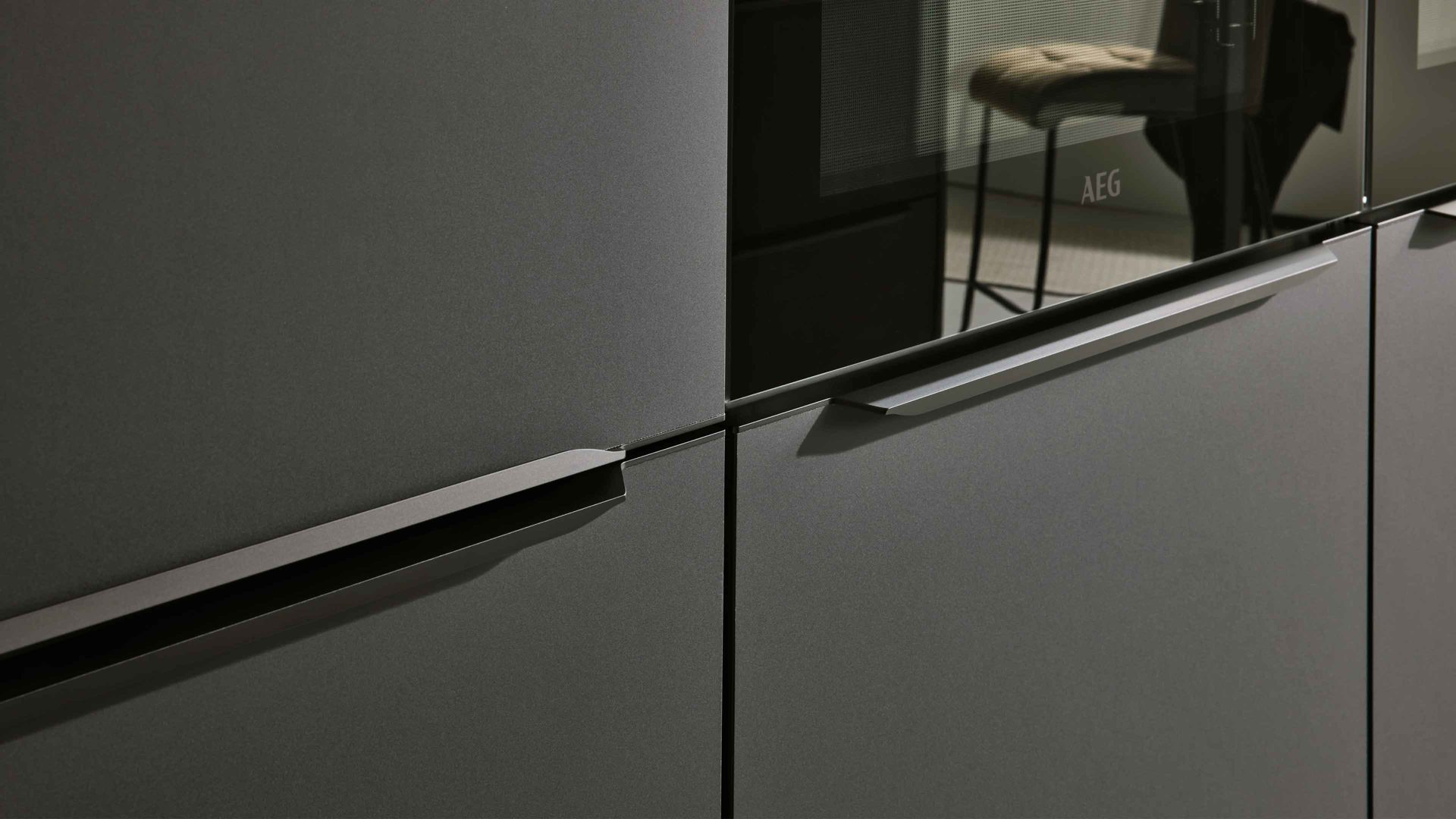 Einbauküche Interliving aus Holz in Schwarz Interliving Küche Serie 3057 mit AEG Einbaugeräten Mattschwarz – zweizeilig